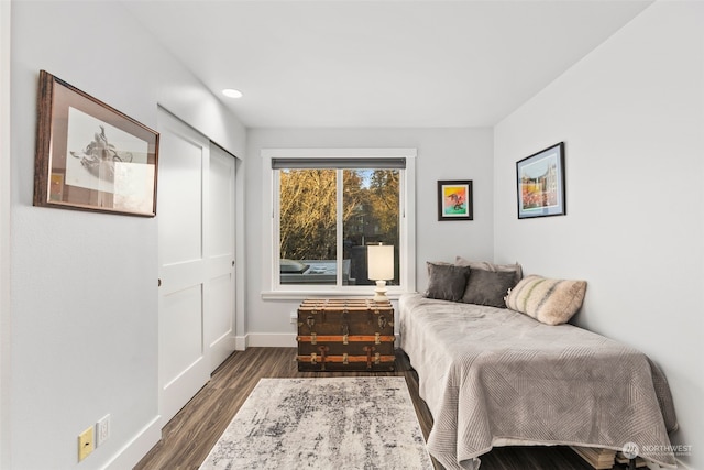 bedroom with dark hardwood / wood-style floors and a closet