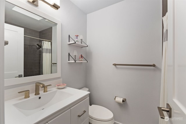 bathroom with walk in shower, vanity, and toilet