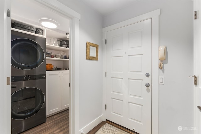 washroom featuring dark hardwood / wood-style flooring, cabinets, and stacked washing maching and dryer