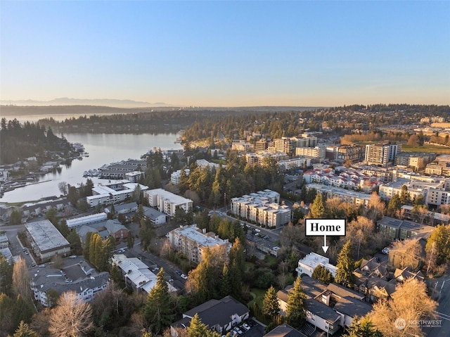 aerial view at dusk featuring a water view