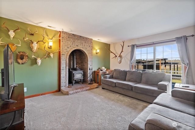 carpeted living room with a wood stove