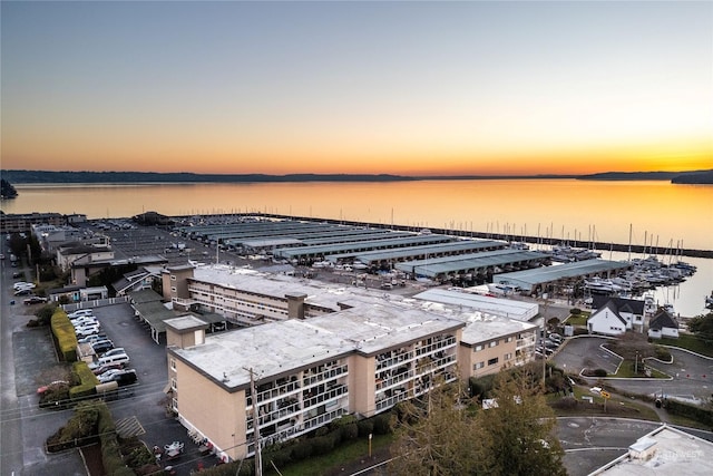 aerial view at dusk featuring a water view