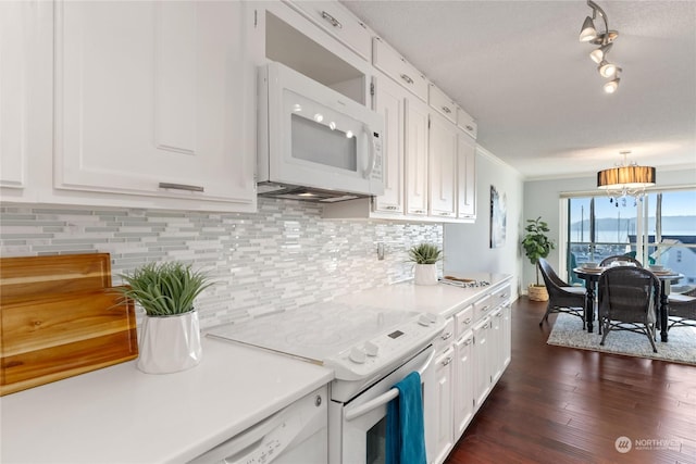 kitchen featuring white appliances, dark wood-type flooring, white cabinetry, decorative backsplash, and decorative light fixtures