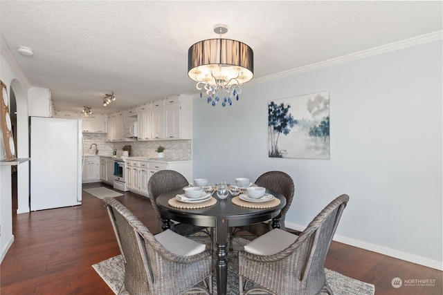 dining area featuring a textured ceiling, ornamental molding, dark hardwood / wood-style floors, and a chandelier