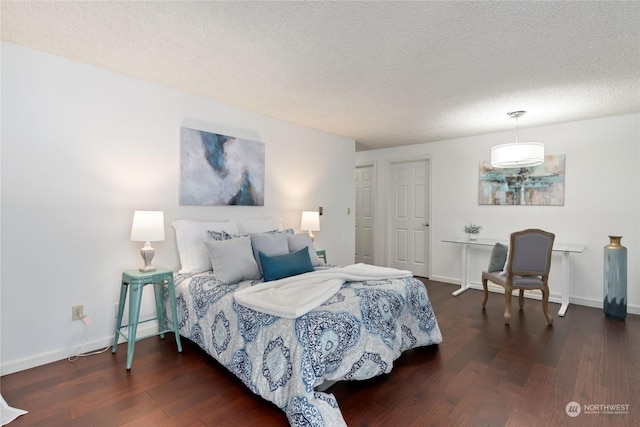 bedroom with dark hardwood / wood-style flooring and a textured ceiling