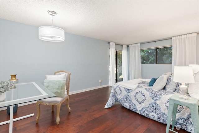 bedroom featuring access to outside, a textured ceiling, and dark hardwood / wood-style flooring