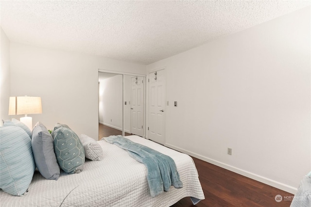 bedroom featuring dark hardwood / wood-style floors, a textured ceiling, and a closet