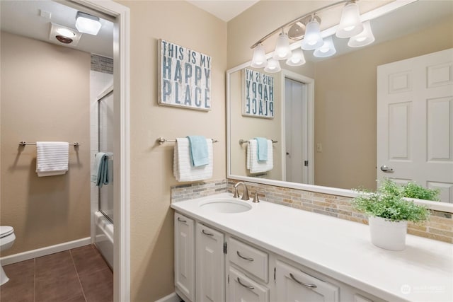 full bathroom with shower / bath combination with glass door, tile patterned flooring, tasteful backsplash, vanity, and toilet