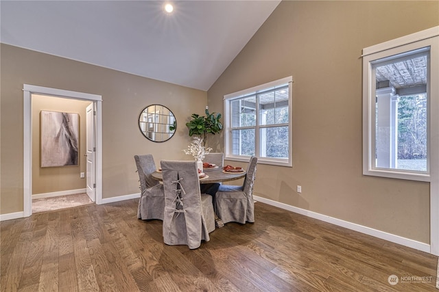 dining area with wood-type flooring and vaulted ceiling