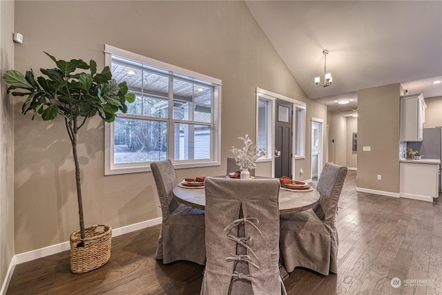 dining room featuring dark wood-type flooring, high vaulted ceiling, and an inviting chandelier