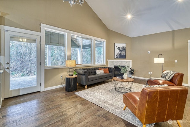 living room with high vaulted ceiling, a fireplace, and hardwood / wood-style floors