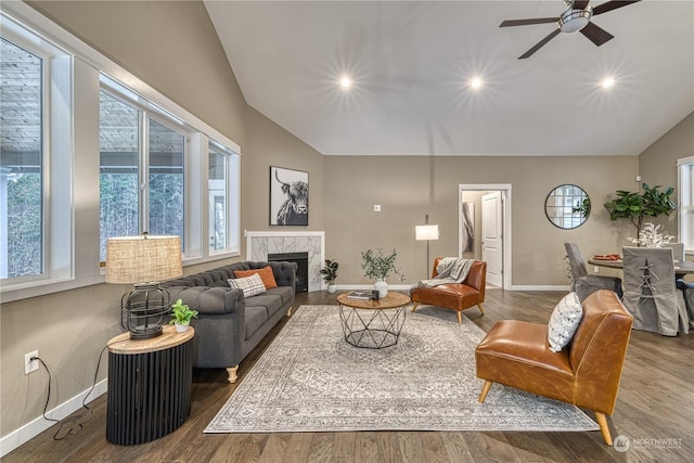 living room featuring a fireplace, dark wood-type flooring, vaulted ceiling, and ceiling fan