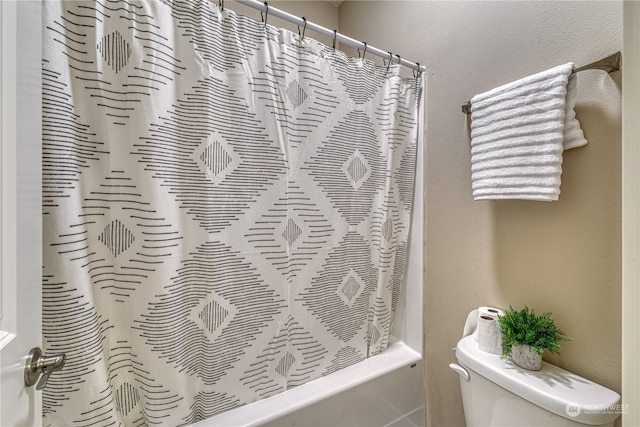 bathroom with shower / bathtub combination with curtain and toilet