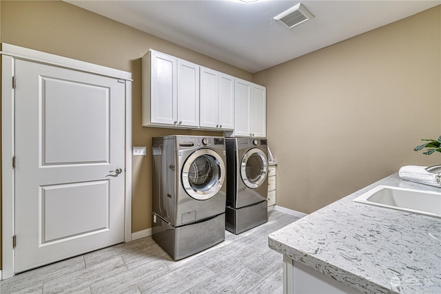 laundry room featuring cabinets, washer and dryer, and sink