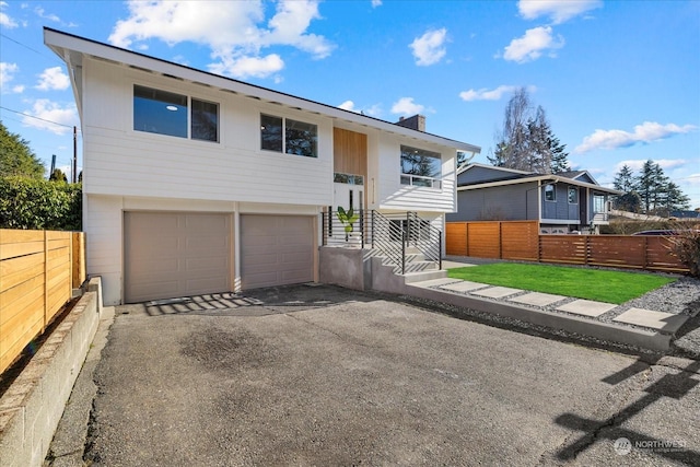 split foyer home featuring a garage and a front yard