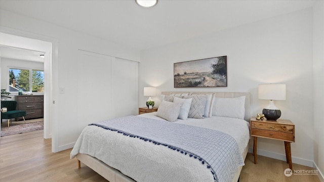 bedroom with light hardwood / wood-style floors and a closet