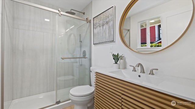 bathroom featuring vanity, walk in shower, and toilet