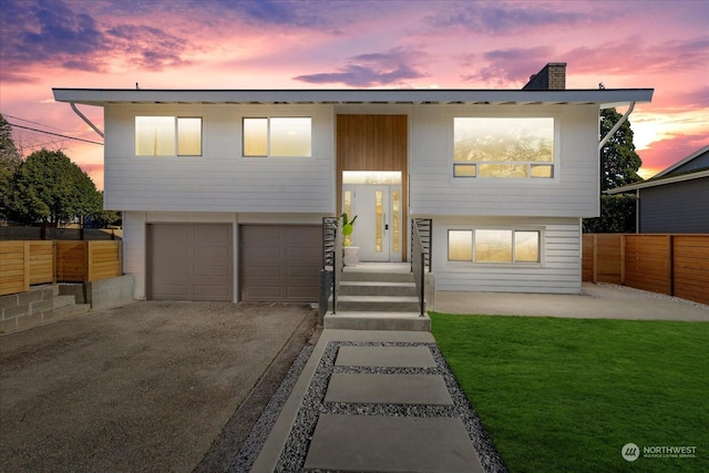 view of front of property with a garage and a yard