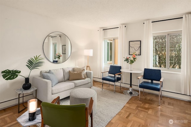 living room with a baseboard heating unit, light parquet floors, and a textured ceiling