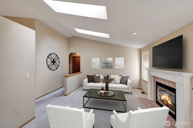 living room with vaulted ceiling, carpet floors, a fireplace, and baseboards