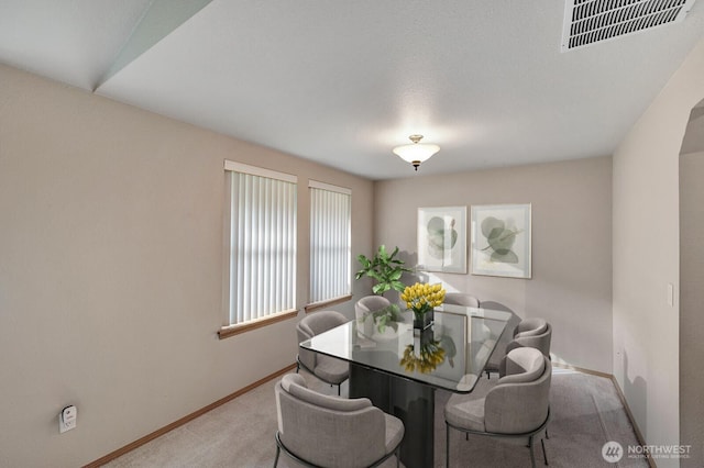 carpeted dining area featuring visible vents and baseboards