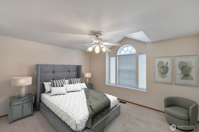 carpeted bedroom with visible vents, vaulted ceiling, a textured ceiling, and baseboards