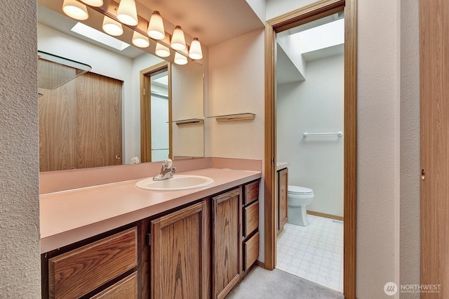 bathroom with toilet, vanity, and tile patterned floors