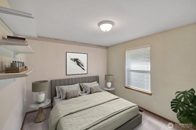 carpeted bedroom with baseboards and wallpapered walls