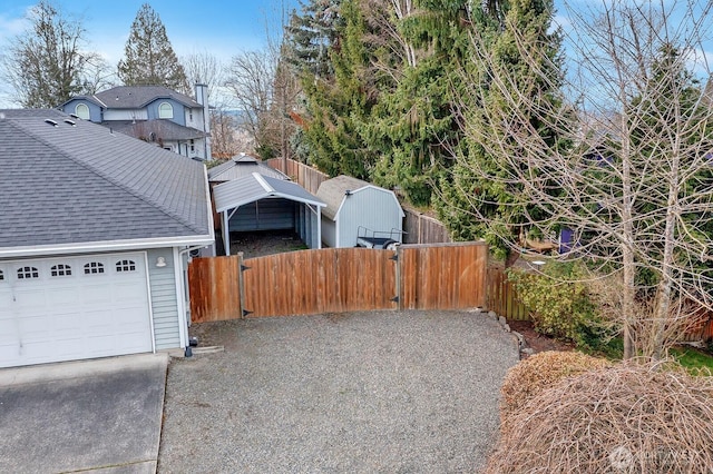 view of property exterior with a shingled roof, a gate, fence, and concrete driveway