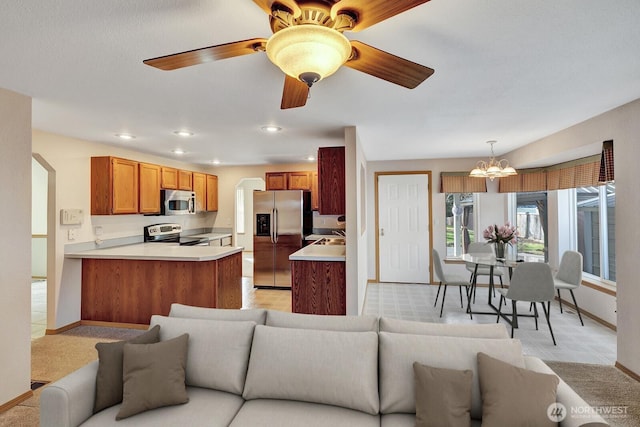 living room with baseboards, ceiling fan with notable chandelier, and recessed lighting