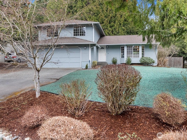 view of front of home with concrete driveway, a garage, and a shingled roof