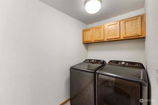 washroom featuring cabinets and separate washer and dryer