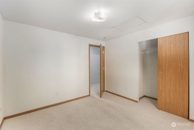 unfurnished bedroom featuring light colored carpet and a closet