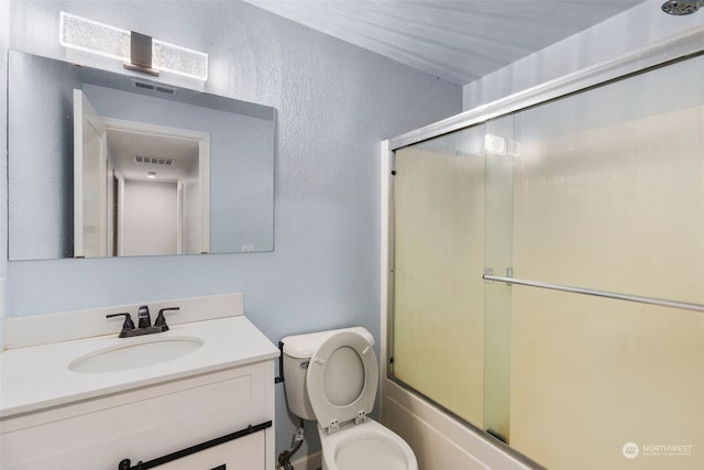 full bathroom featuring bath / shower combo with glass door, vanity, and toilet