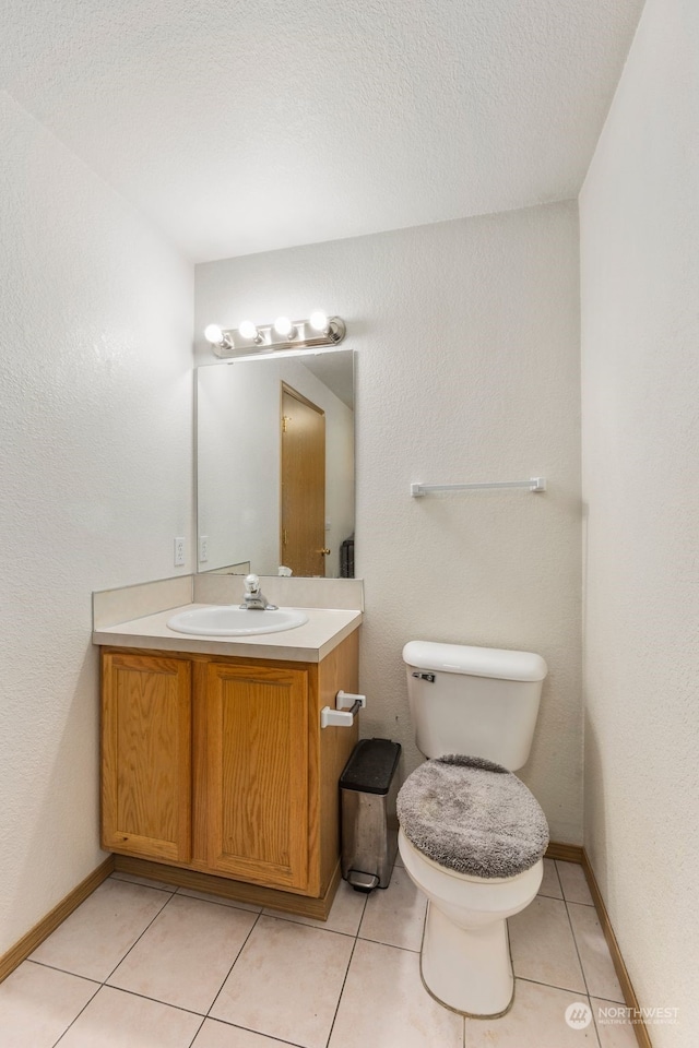 bathroom with vanity, tile patterned flooring, a textured ceiling, and toilet