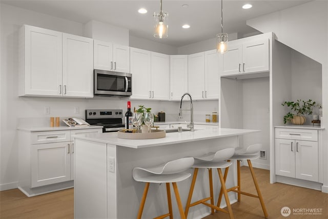 1510E Hollow Dale Pl, Everett, WA 98204 - kitchen featuring stainless steel appliances, light wood-style floors, a sink, white cabinetry, and recessed lighting