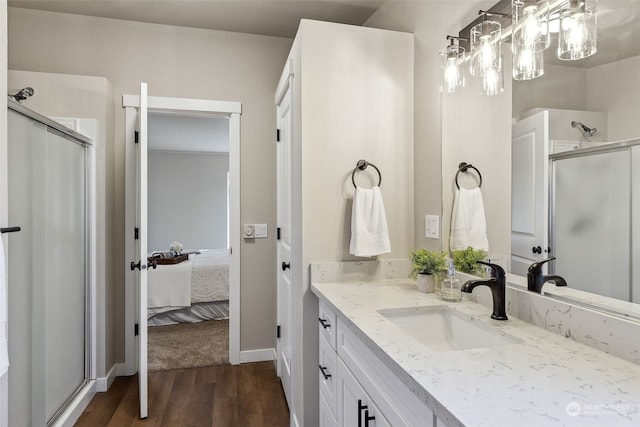 bathroom featuring walk in shower, wood-type flooring, and vanity