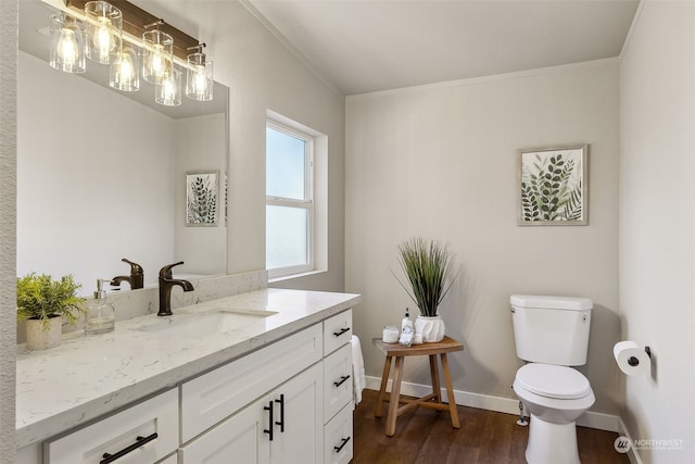 bathroom with hardwood / wood-style flooring, ornamental molding, vanity, and toilet