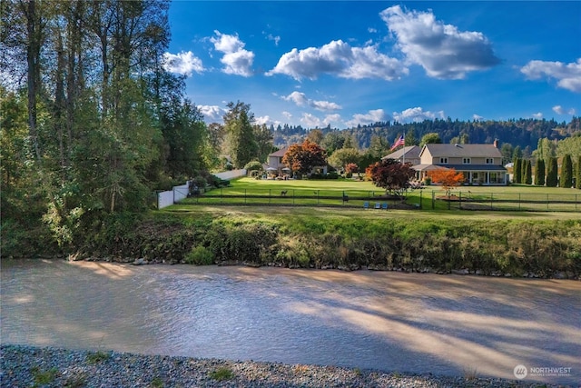 surrounding community with a water view and a yard