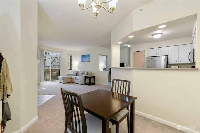 carpeted dining area featuring a chandelier