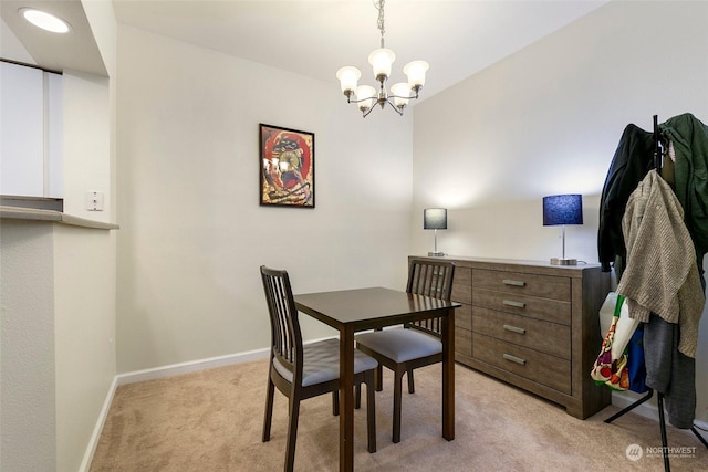 carpeted dining space featuring a notable chandelier