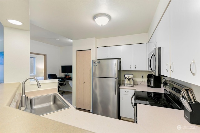 kitchen with appliances with stainless steel finishes, sink, and white cabinets