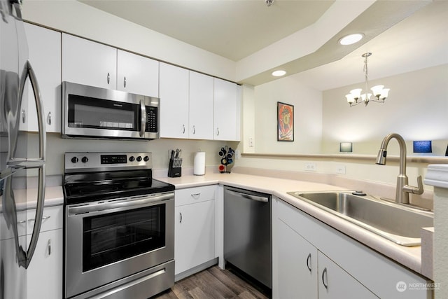 kitchen featuring sink, white cabinetry, decorative light fixtures, dark hardwood / wood-style flooring, and stainless steel appliances