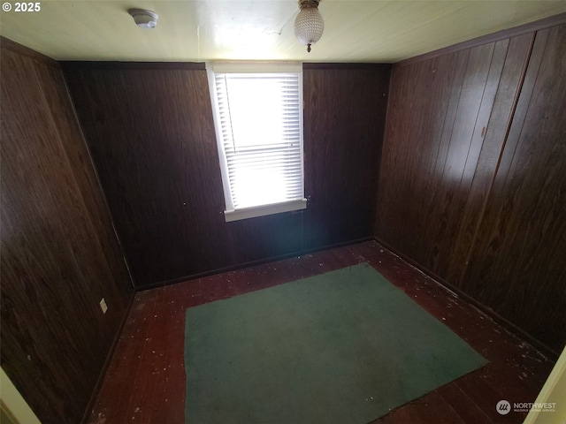 unfurnished room featuring wooden walls