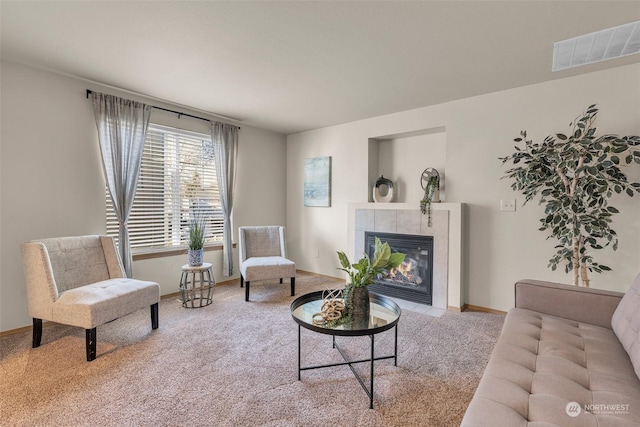 living room with a tile fireplace and light colored carpet