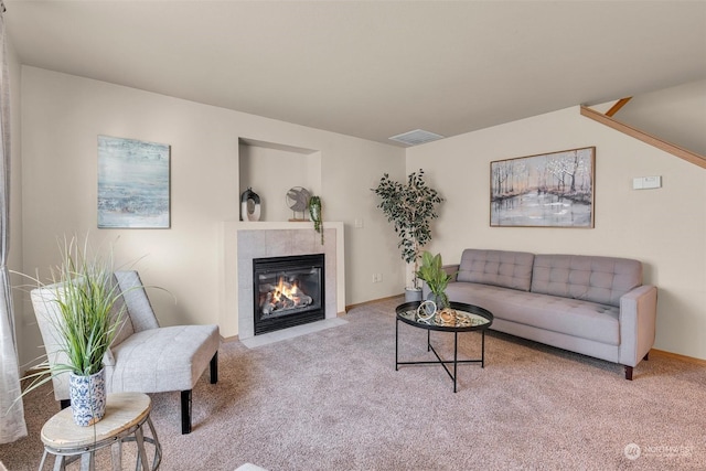 carpeted living room featuring a tiled fireplace