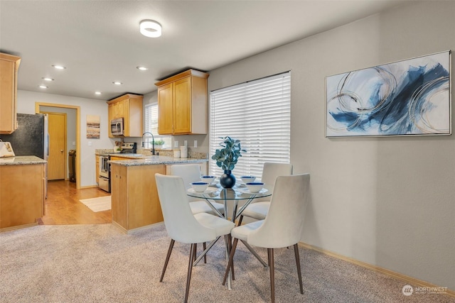 dining space featuring light carpet and sink