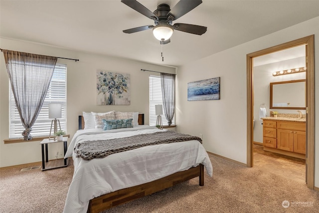 carpeted bedroom featuring ensuite bathroom, sink, and ceiling fan