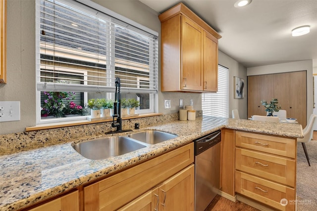 kitchen with light stone countertops, sink, stainless steel dishwasher, and kitchen peninsula