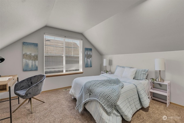 bedroom with vaulted ceiling, light colored carpet, and a textured ceiling